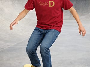 Teen boy model on skateboard wearing a graphic logo tee