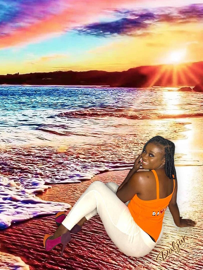 A woman sitting on the beach in front of water.